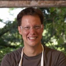 Profile picture of man with brown hair and glasses smiling