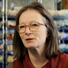 Female with brown shoulder length hair and  glasses